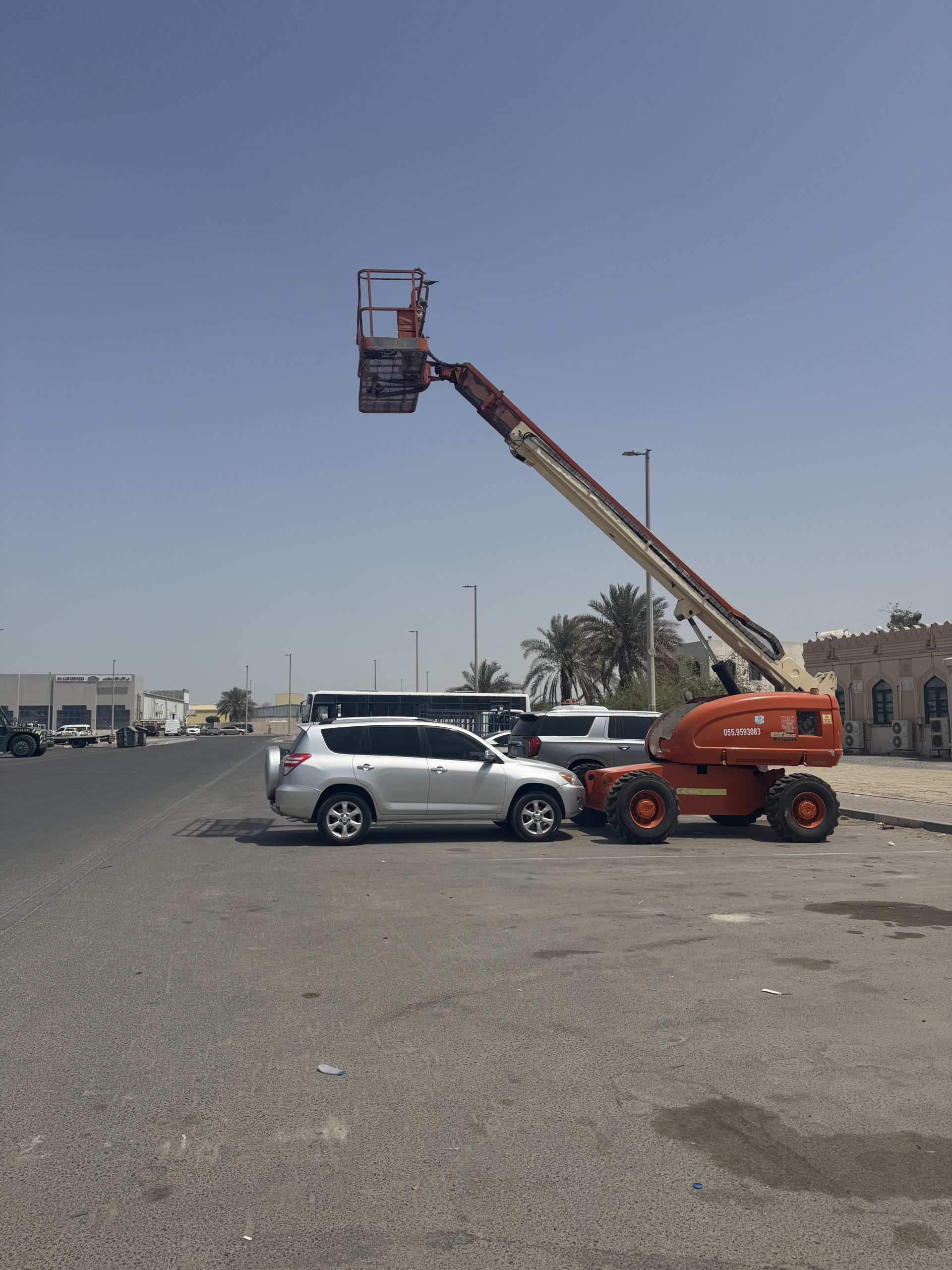White gold General Transport boom lift for elevated work and aerial access.